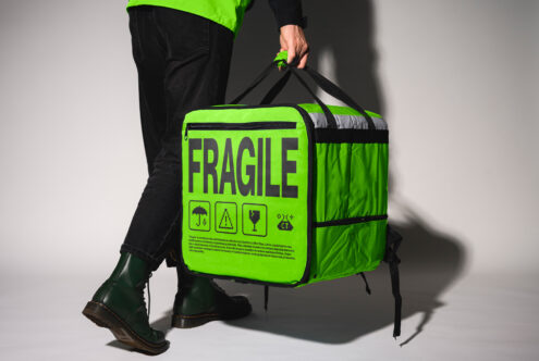 Bright green mockup of a fragile package bag with bold lettering and warning icons perfect for delivery branding or graphic design presentations.