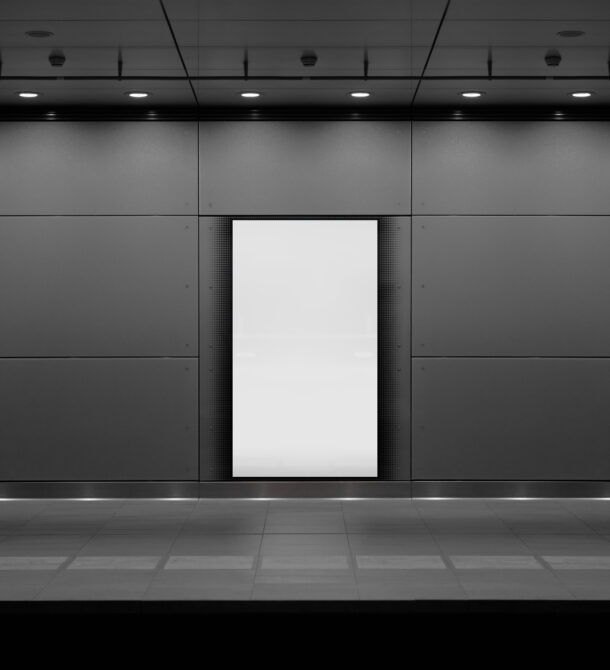 Indoor retail display mockup, white panel on dark wall with ceiling lights
