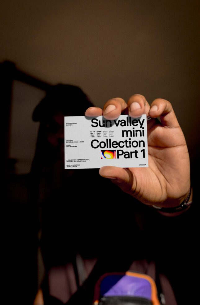 Person holding a card with text Sun Valley mini Collection Part 1 in a dimly lit setting suitable for mockup designers marketing branding graphic design typography.