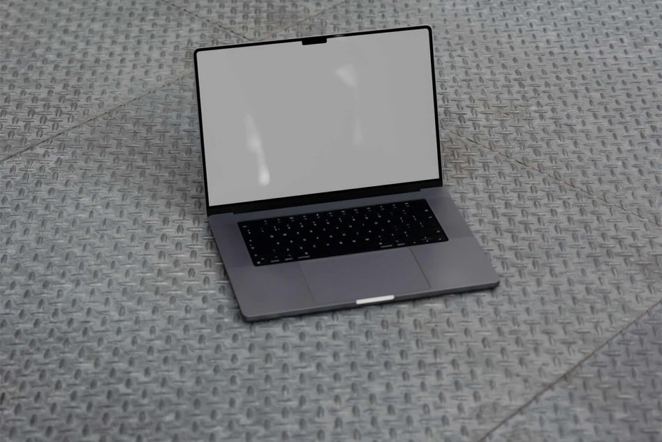 Laptop on gray textured surface with blank white screen display