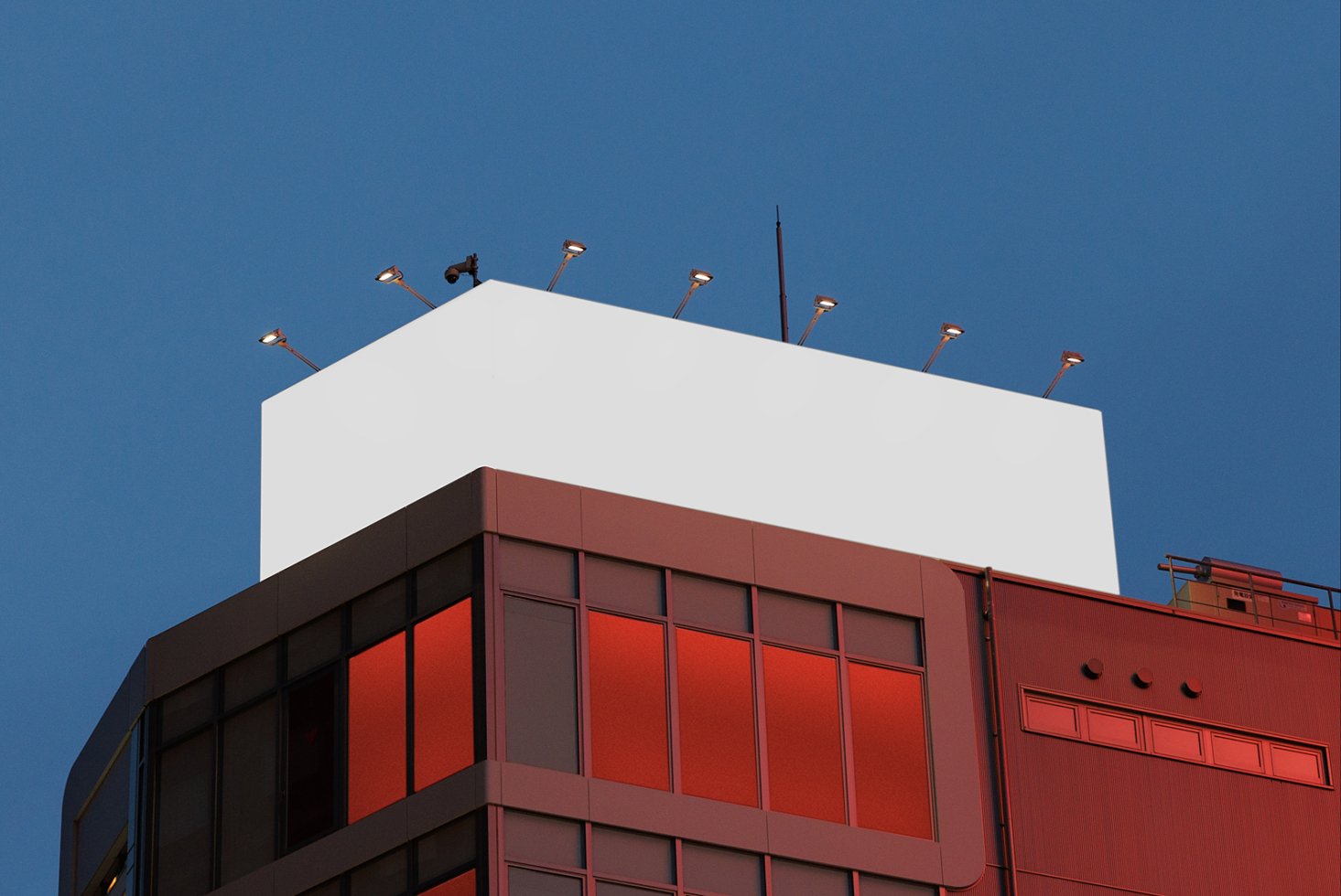 Rooftop billboard mockup on modern building at dusk blue sky background. Ideal for designers creating outdoor advertising templates and graphic displays.