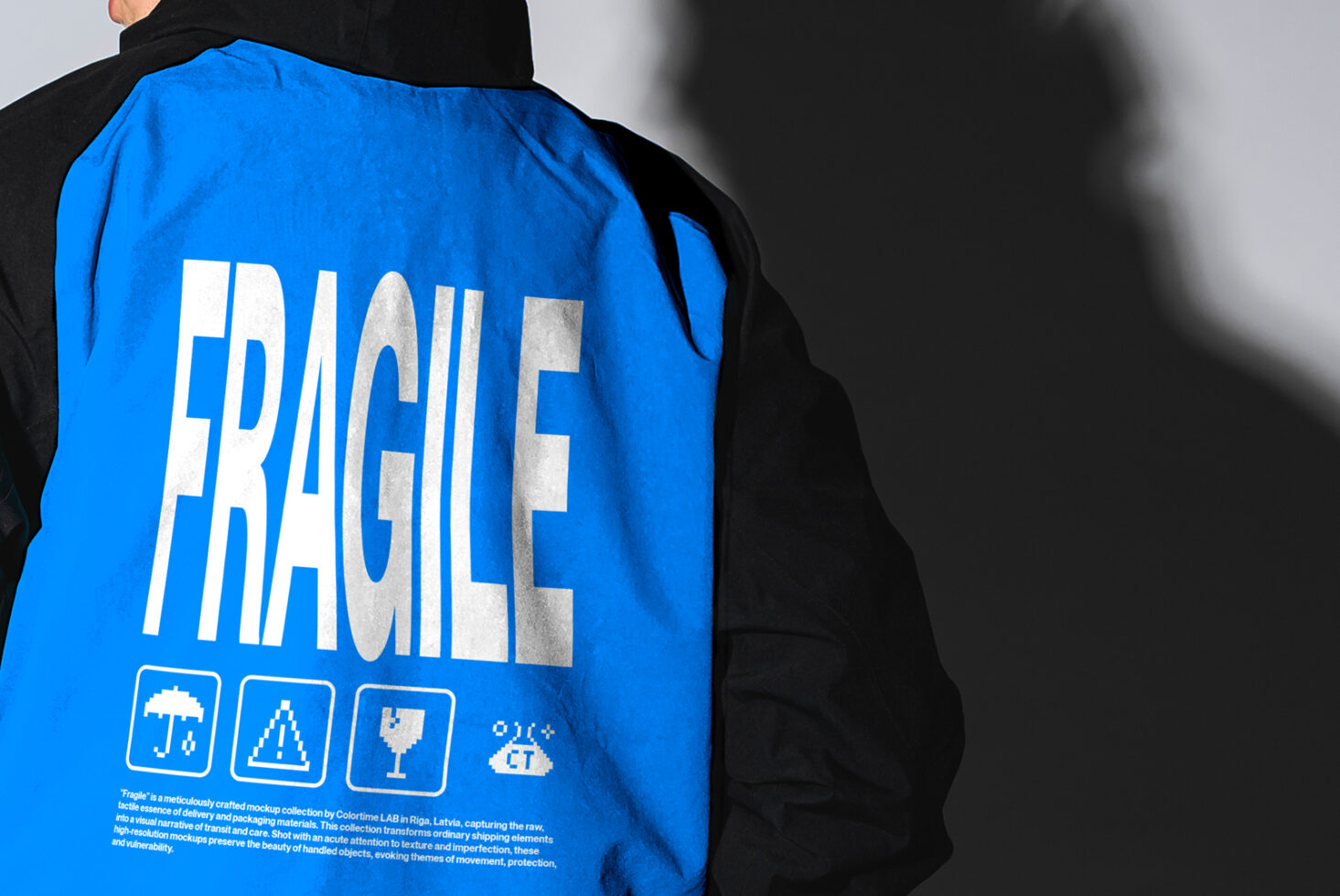 Man in a jacket with FRAGILE text design in bold white on blue. Ideal for fashion mockups. Urban style. Shadow contrasts. Apparel graphic design asset.
