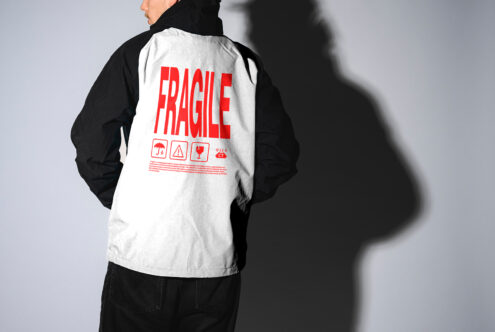 Man in black and white jacket with red Fragile text and symbols. Perfect for designers seeking creative apparel mockups. Fashion design asset.