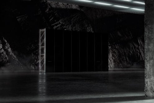 Dark industrial interior showcasing a minimalist black structure with metal framework and concrete textures. Ideal for mockups and graphic design.