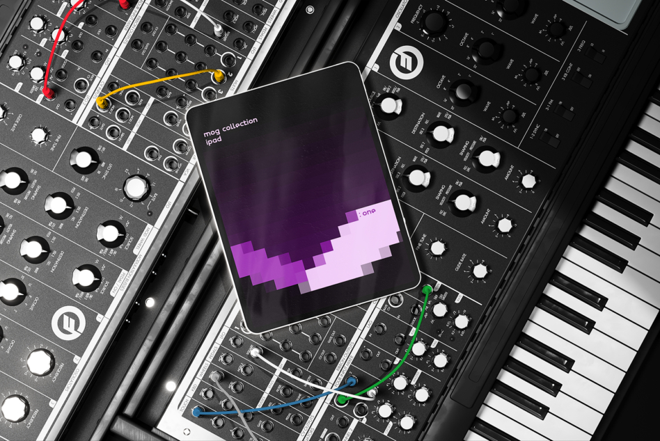 iPad displaying mog one screen among synthesizer modules with colored cables
