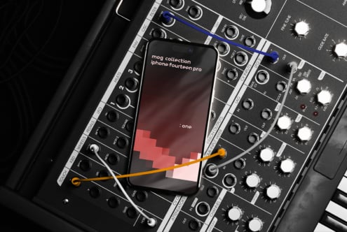 Mockup of a smartphone displaying a digital design interface, placed on an audio synthesizer with cables connected. Ideal for designers, tech, UI, UX.