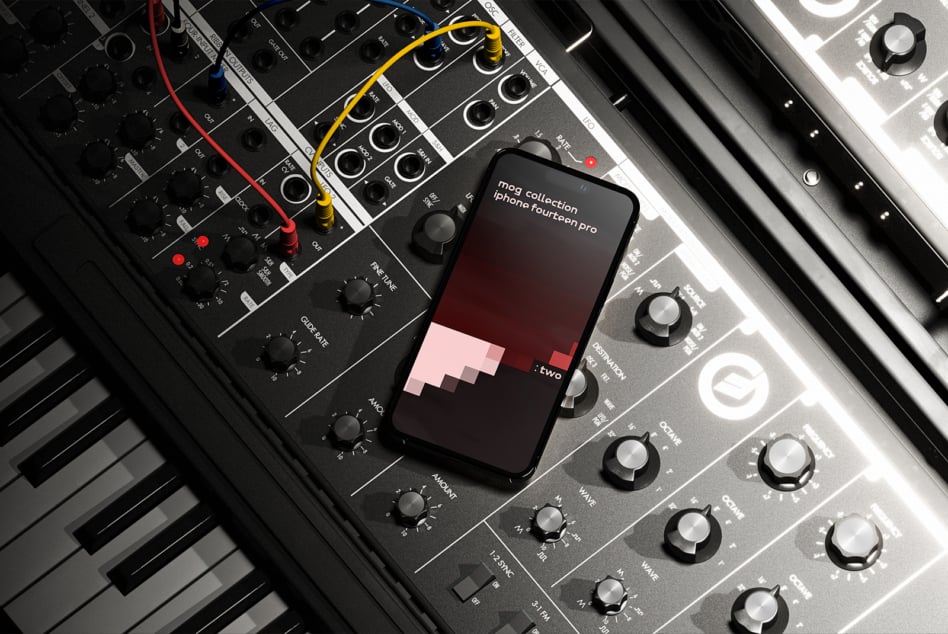 iPhone 14 Pro angled on music gear setup with colorful cables, red gradient display
