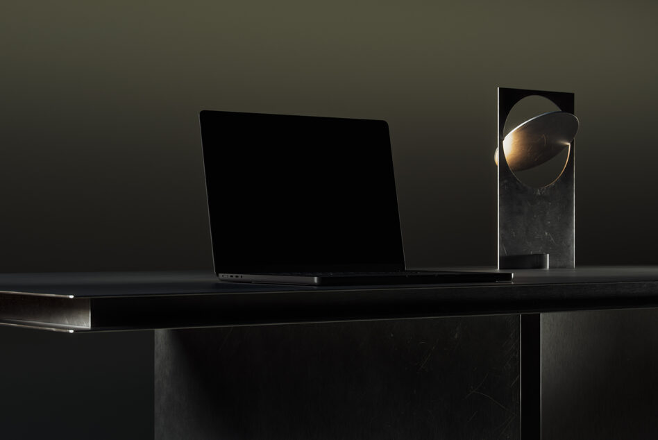 Laptop with blank screen next to decorative sphere on shelf