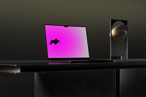 Sleek laptop mockup with vibrant pink display on dark desk; ideal for showcasing graphic design projects and digital assets in modern workspace settings.