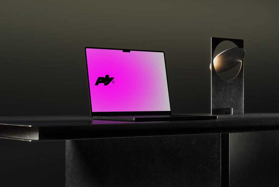 Laptop displaying vibrant magenta gradient with logo on desk setup