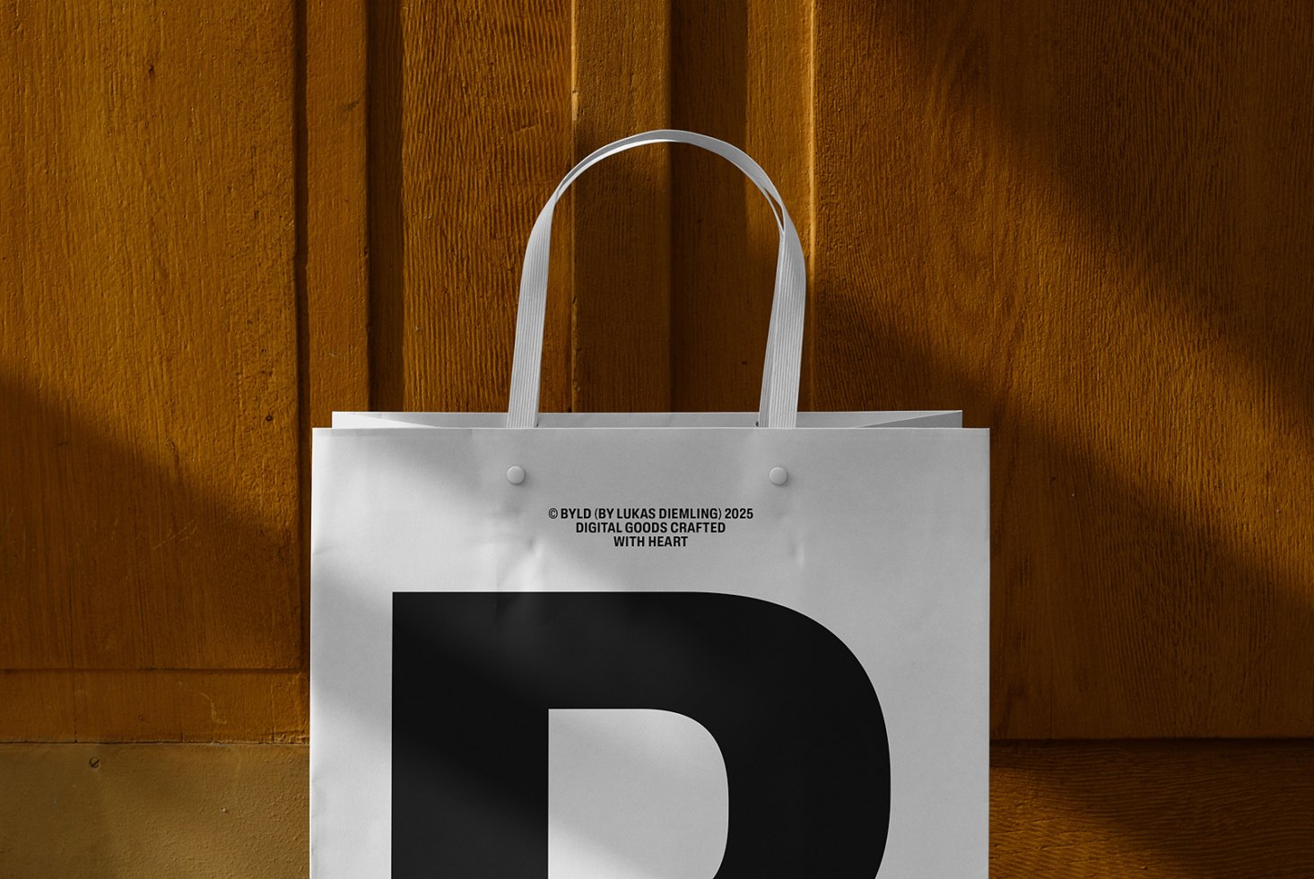 White paper bag with black letter D against wooden background ideal for mockup. Perfect for showcasing branding packaging design templates for designers.