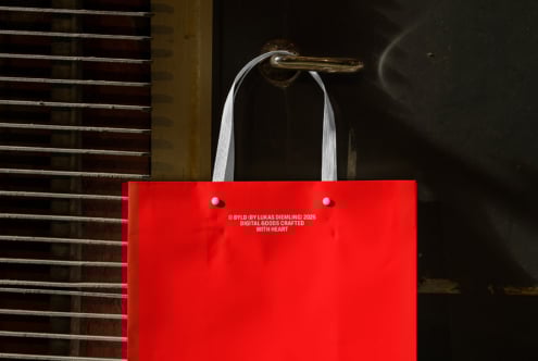 Red tote bag with white handles on metal door handle. Ideal for mockup, template design projects. Enhance branding visuals for designers.