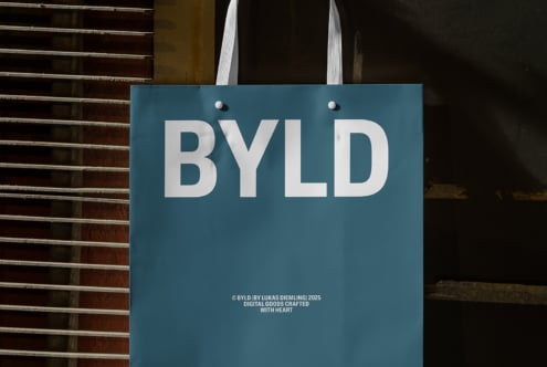 Teal paper bag mockup with bold white BYLD text useful for graphic designers. Ideal for branding presentations or digital asset creation.