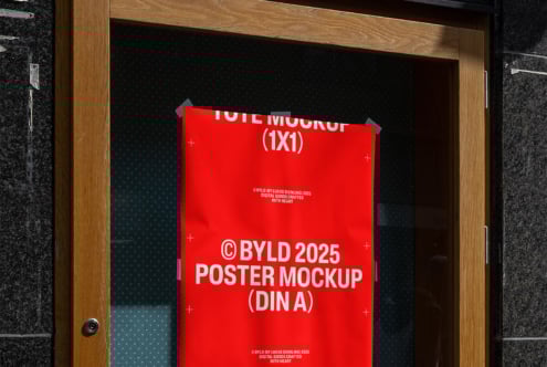 A red poster mockup placed on a wooden door perfect for showcasing DIN A sized designs. Ideal for designers looking for realistic presentation templates.