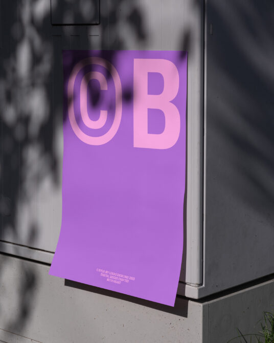 Vibrant magenta poster with pink CB letters leaning on grey wall