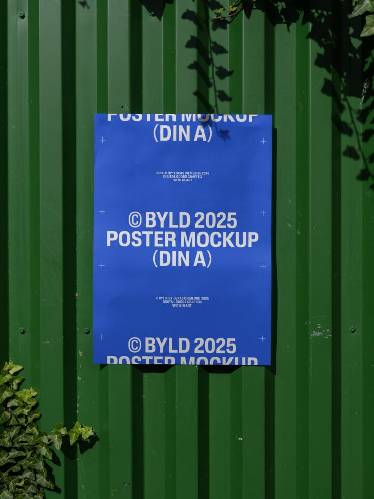 Blue poster mockup on a green textured wall surrounded by foliage suitable for graphic designers. Perfect for showcasing poster designs or templates.