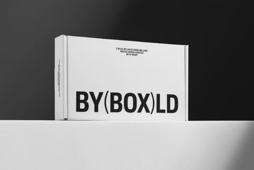 Minimalist white packaging box mockup on black and white backdrop suitable for branding and product design showcasing bold sans-serif typography