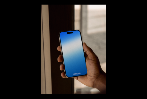 Person holding smartphone with blank blue screen, ideal for app mockup, user interface design, digital asset, graphic template for designers.