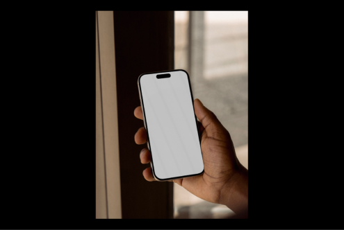 Hand holding a smartphone with blank screen for mockup template design showcased in natural light perfect for digital designers and app developers.