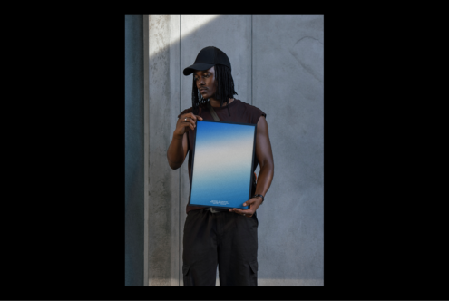 Designer holding blank blue poster mockup against gray concrete wall perfect for showcasing graphics templates marketing presentations photography.