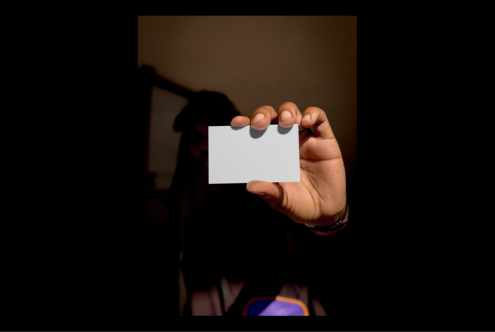 Hand holding blank business card against dark background ideal for mockups freelance designers brand identity marketing graphics clean professional layout