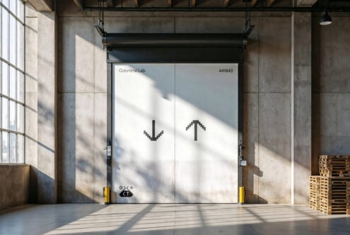 Industrial warehouse door with pixel arrow graphics sunlight casting shadows Colortime Lab signage minimalist design ideal for mockup templates industrial theme