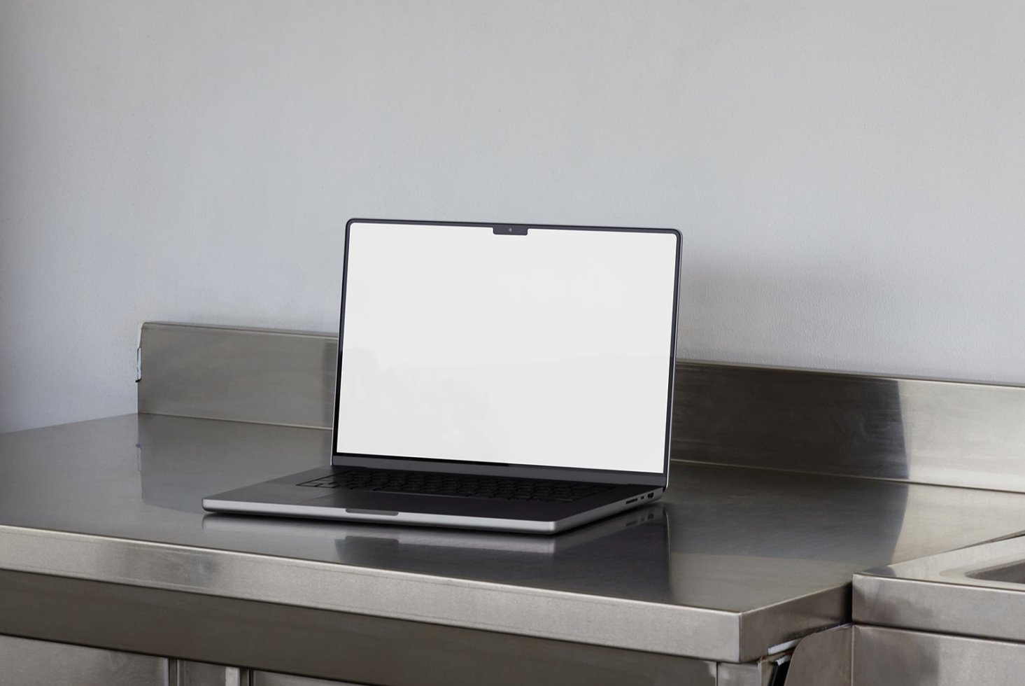Laptop mockup on a metallic surface perfect for showcasing web designs or graphic templates. Ideal for designers seeking realistic presentation tools.