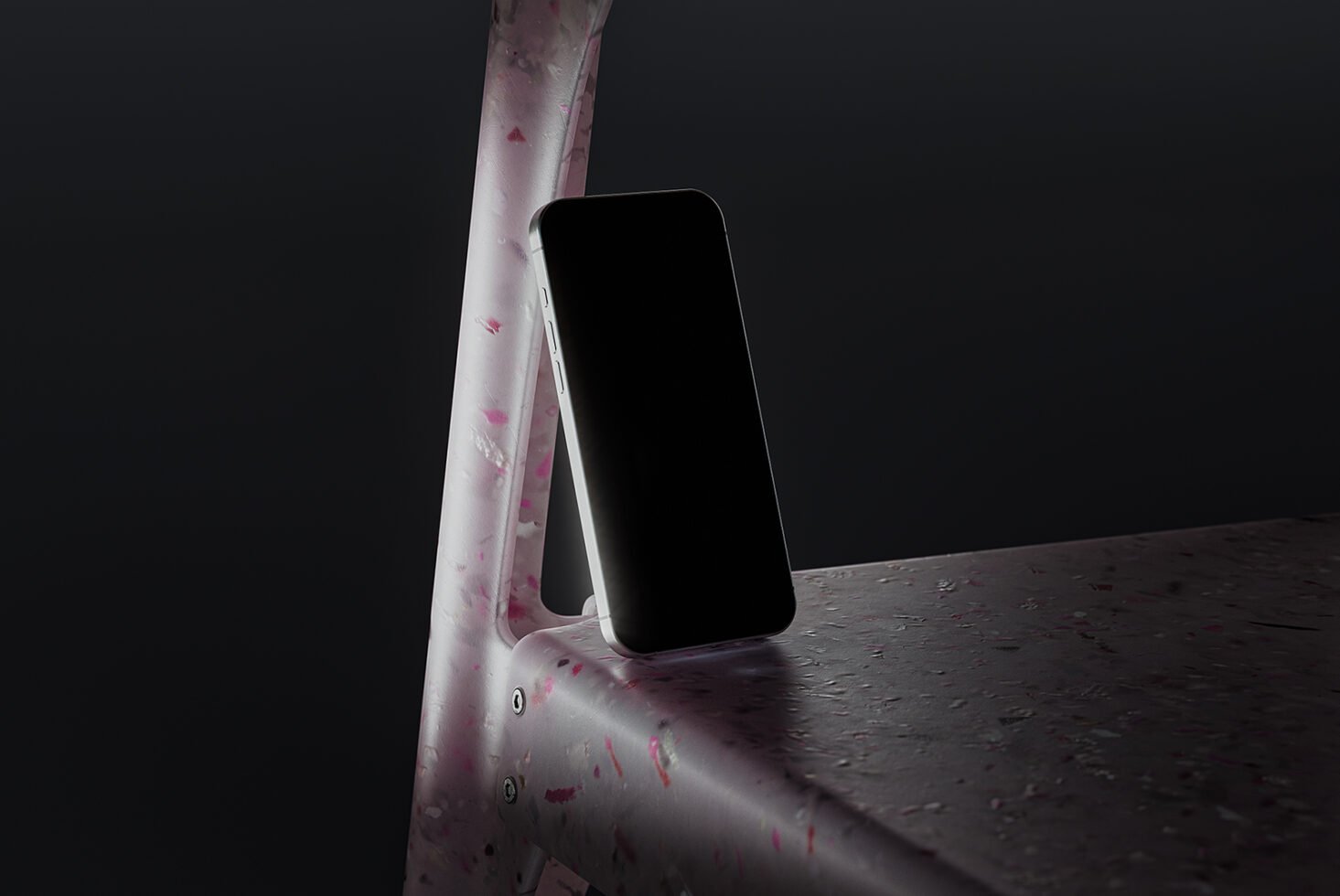 Smartphone leaning on terrazzo pink chair with dark background. Ideal for creating mockups, design presentations, and digital assets. Moody lighting.