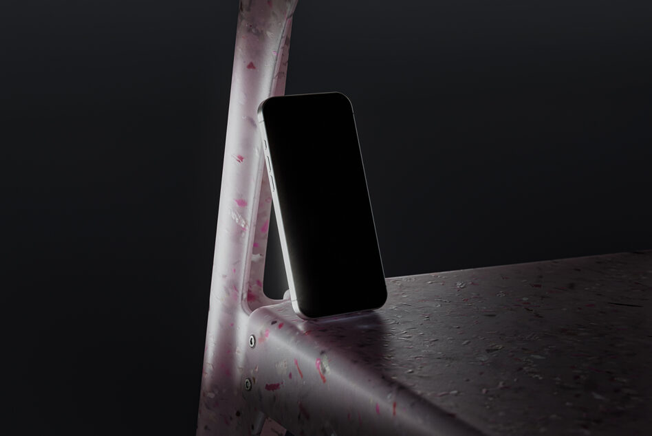 White phone leaning on textured pink pole in dark moody space