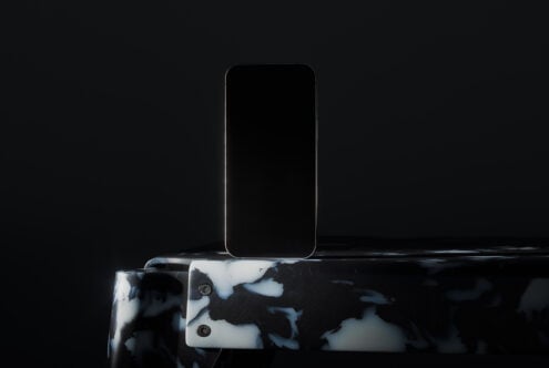 Dark elegant smartphone mockup standing on a marbled surface suitable for showcasing app designs or digital content in professional settings