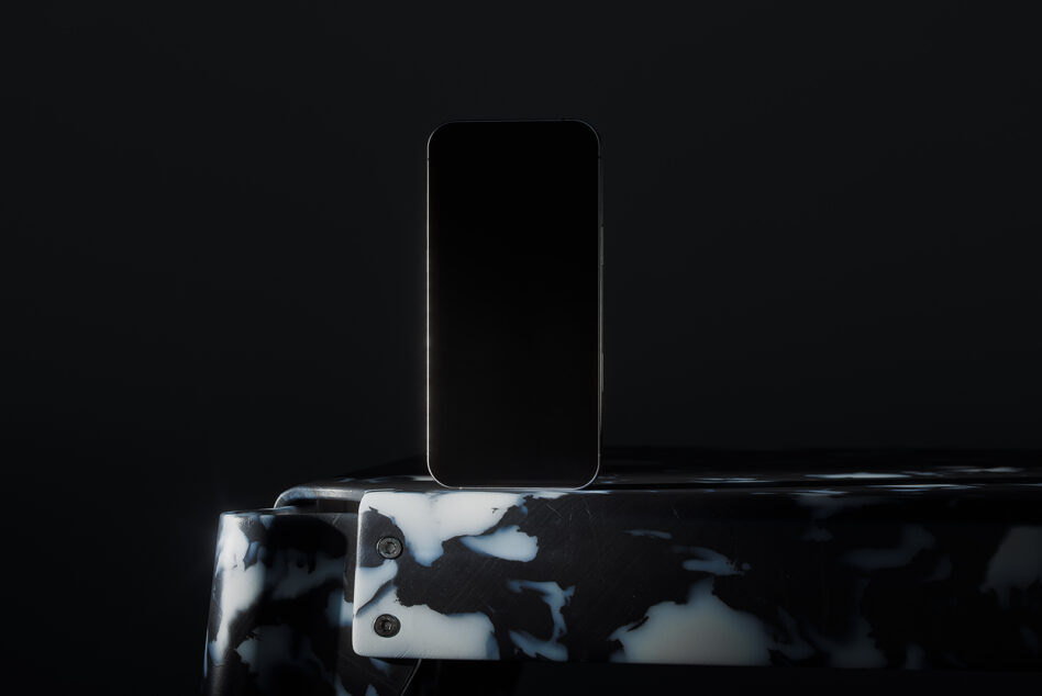 Phone mockup with blank black screen mounted on marble patterned stand in studio lighting