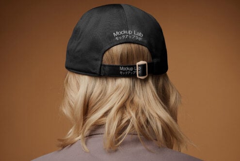 Back view of person wearing a black baseball cap with adjustable strap featuring embroidered text Mockup Lab suitable for fashion designers or branding mockups.