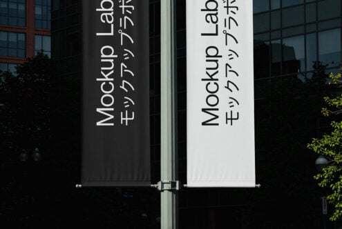 Street pole banners mockup with vertical text on black and white fabric backgrounds. Ideal for graphic designers to showcase branding and typography.