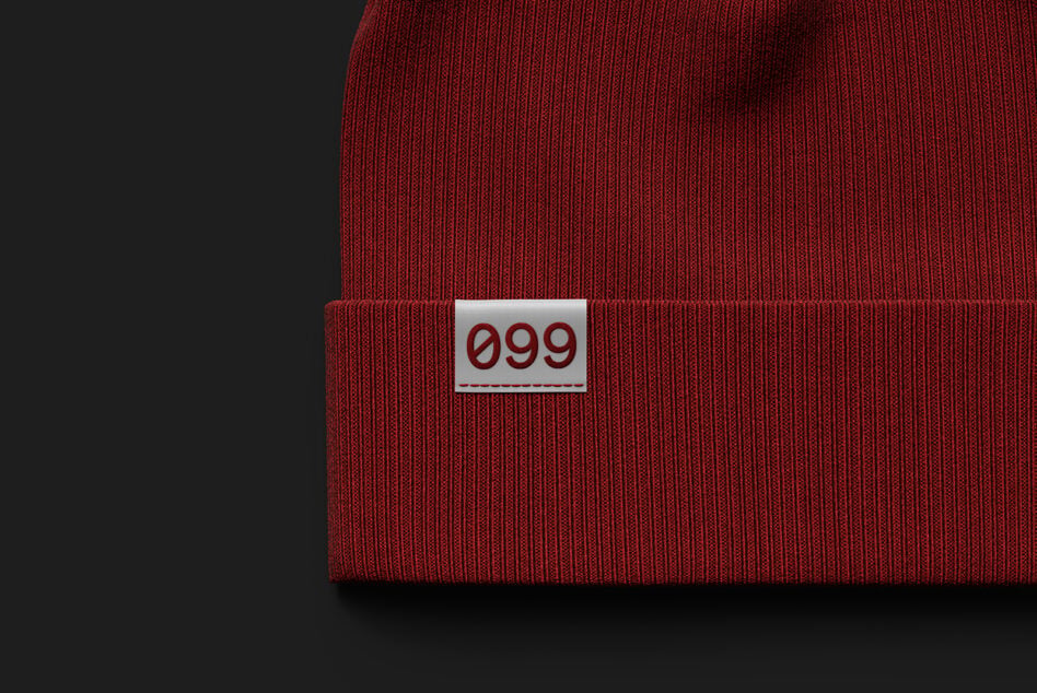 Crimson red ribbed knit beanie with numbered label patch visible
