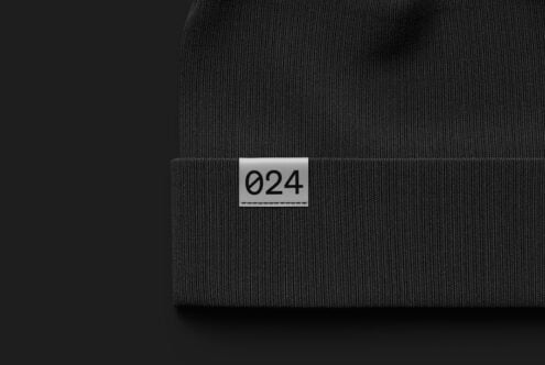 Black beanie mockup featuring a close-up view of a fabric tag with numbers. Ideal for fashion branding projects and design showcasing. High-quality textile.