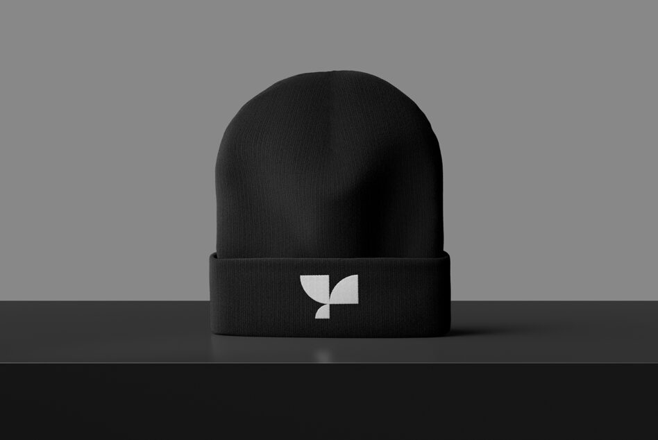 Black knit beanie with white geometric leaf logo on front