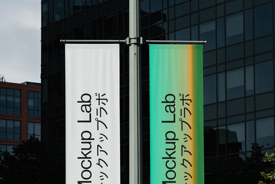 Pair of hanging banners with gradient green to yellow fade showing Mockup Lab branding outdoors