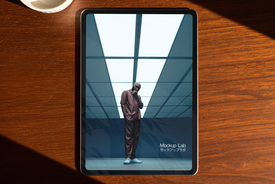 iPad mockup showing person in burgundy suit under geometric ceiling grid