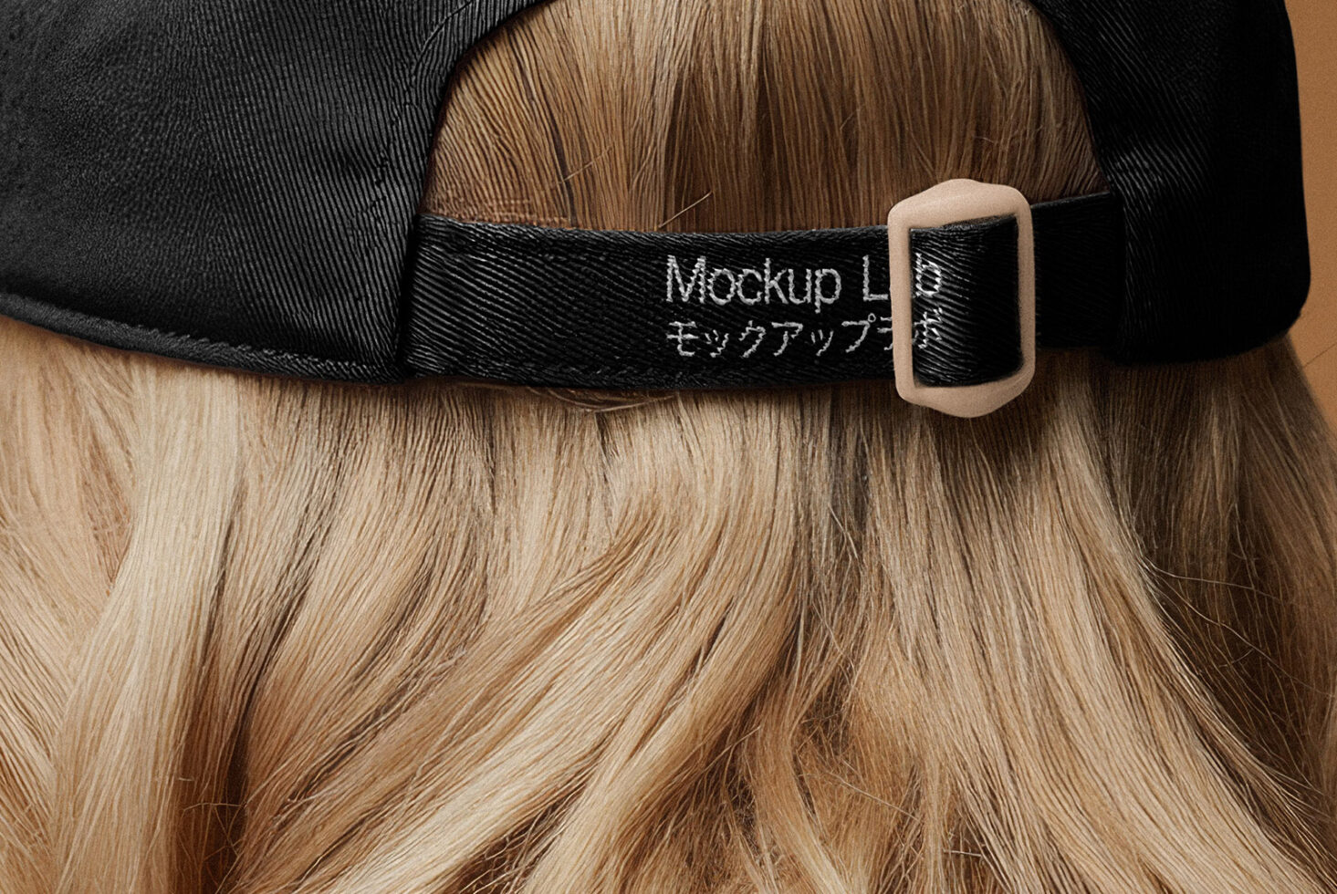 Black cap mockup showcasing adjustable strap on long blonde hair. Ideal for apparel design presentations. Download high-quality graphics for designers.