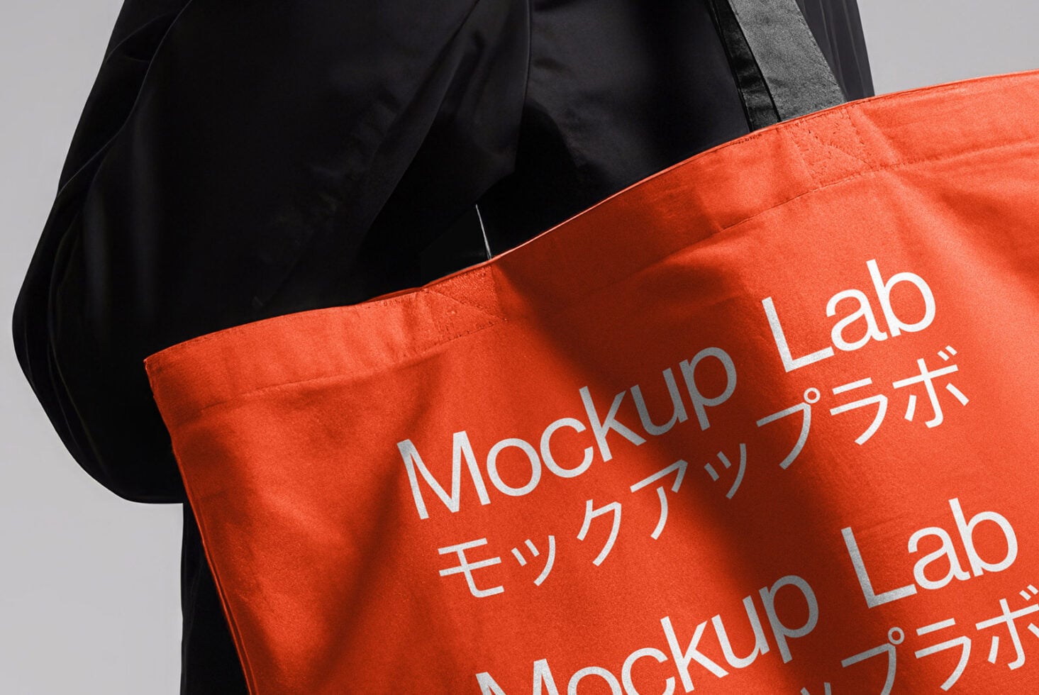 Bright orange tote bag with white text being held by person in black
