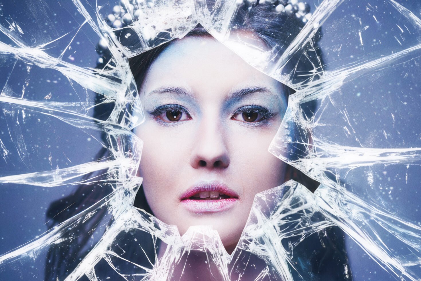 Shattered glass effect surrounding a woman's face with icy tones. Perfect for designers looking for striking graphic templates or creative mockups.