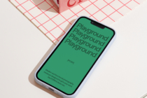 White iPhone mockup with green screen on pink grid background