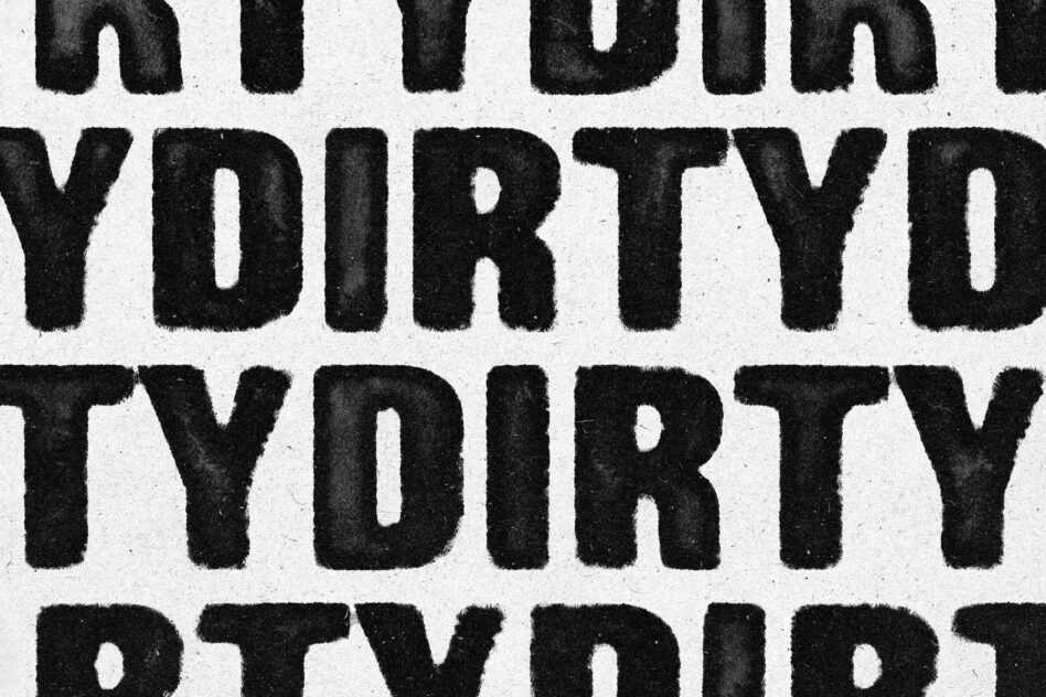 Multiple lines of distressed black serif letters stacked vertically on textured white surface