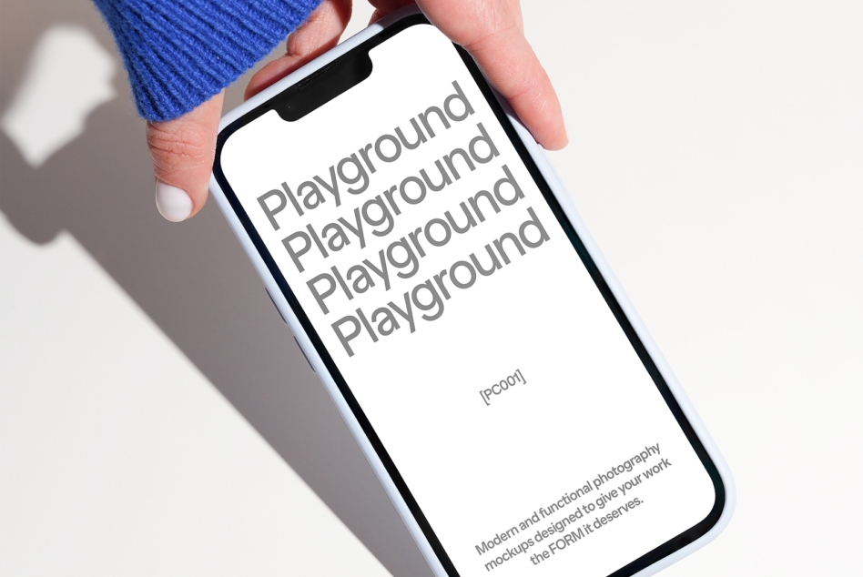 Phone held in hand with white screen displaying stacked Playground text