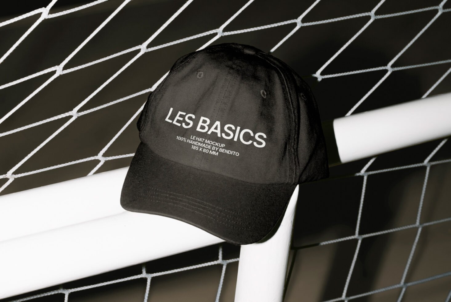 Black cap mockup with white text leaning on a wire fence design perfect for graphic templates fashion prototypes design assets mockups for designers