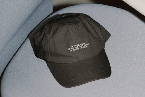 Black cap on gray fabric surface featuring text mockup design 185x80 mm ideal for designers looking for realistic hat templates and digital mockups