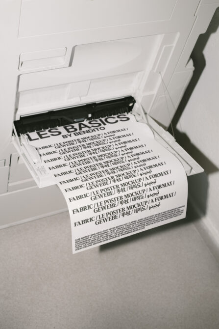 Printer outputting a fabric poster mockup with bold typography. Ideal for designers looking for customizable print templates. Mockups category.