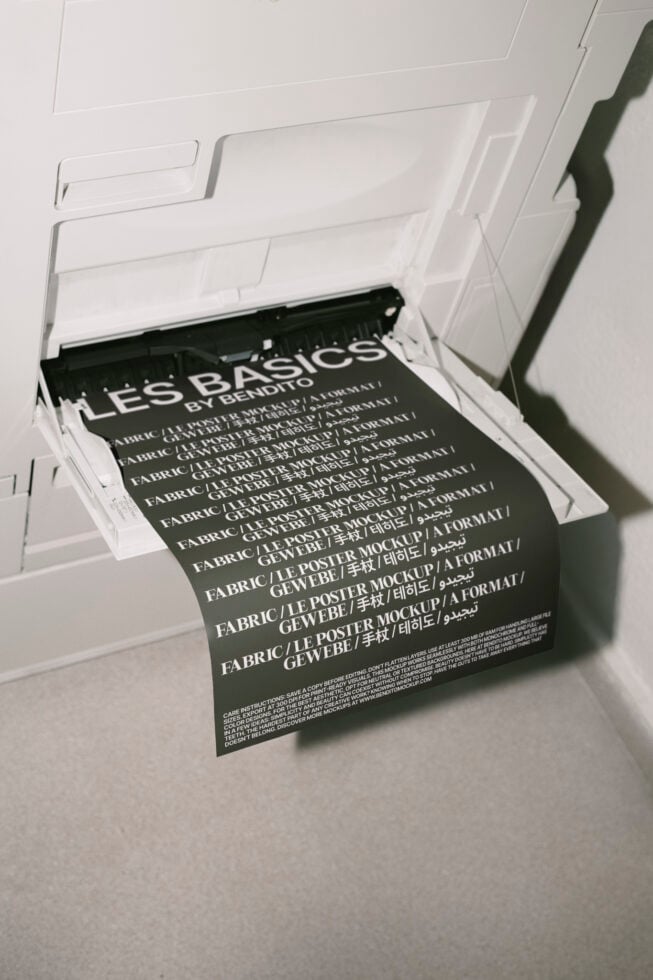 Printer tray with dark poster mockups fanned out showing fabric print mockup