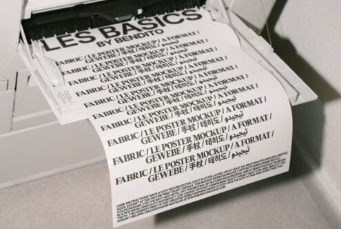 Printer outputs fabric poster mockup with multilingual text; ideal for designers. Keywords: mockup, poster, design, fabric, multilingual text.