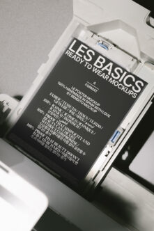 Dark poster mockup inside white organizer box showing Les Basics Ready To Wear